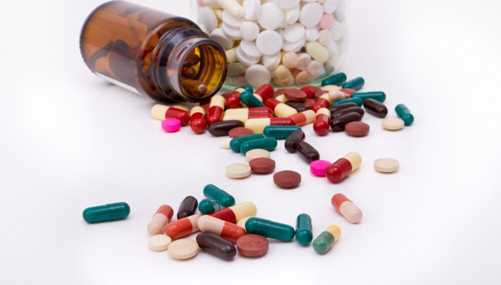 colorful tablets and capsules in glass container