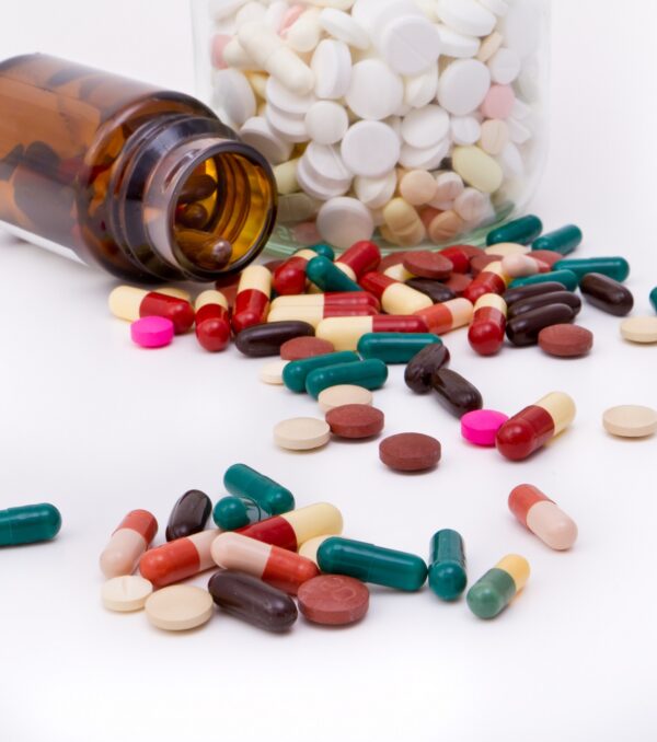 colorful tablets and capsules in glass container